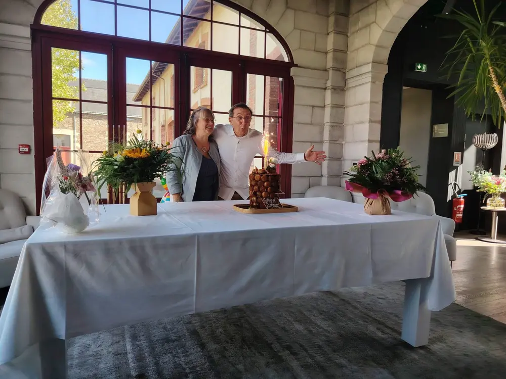 Table dressée avec une nappe blanche devant les grandes baies de la salle du restaurant Le Preti
